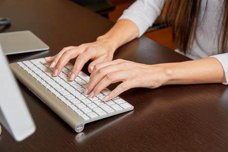 在电脑键盘上键入的女人