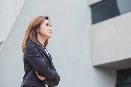 亚洲的工作女人想或商业的女孩儿的思想与建筑建筑背景