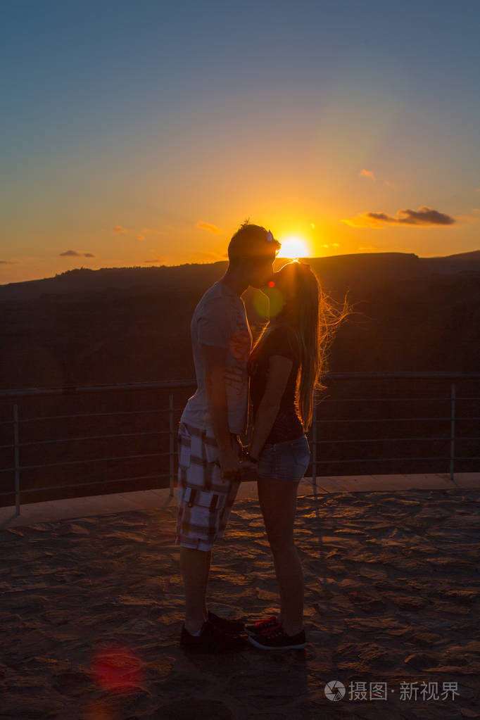 美丽的情侣在日落时接吻