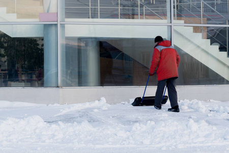 一个工人在大邮政前的暴风雪中清除积雪。