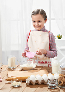 女孩烹调在家庭厨房, 筛面粉通过筛子, 健康食物概念