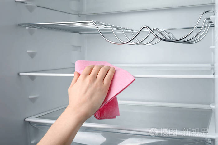 妇女清洁冰箱与抹布, 特写镜头