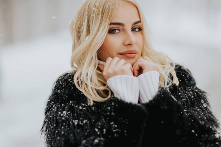 美丽的年轻金发女子在白雪皑皑的冬日