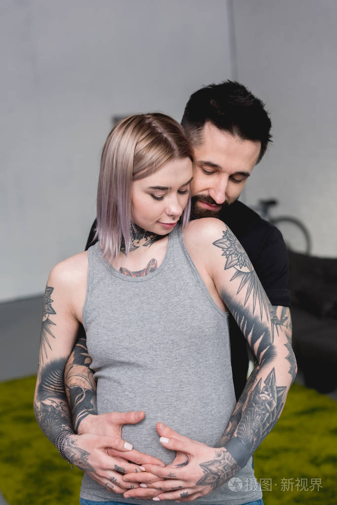快乐纹身男友抱着怀孕的女友从家里回来