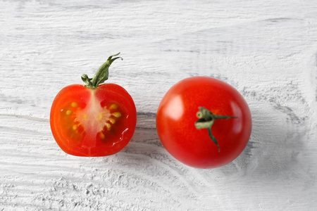 红番茄和轻木背景上的半片