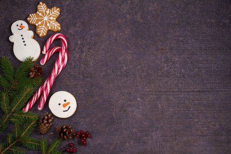 圣诞作文与糖果手杖, 冷杉树枝和生姜面包饼干。黑色背景的冬季节日饰品。平躺, 顶部视图