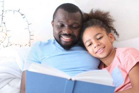 男人读睡前故事给女儿看