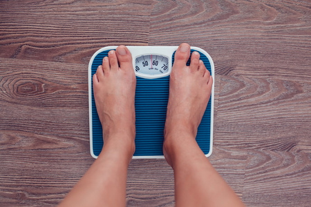 大蒜到磅秤上女孩测量她的体重到磅秤上照片