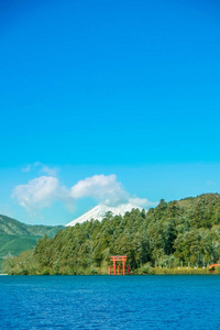 红牌坊下湖芦之湖与富士山在日本箱根明亮晴朗蓝天下