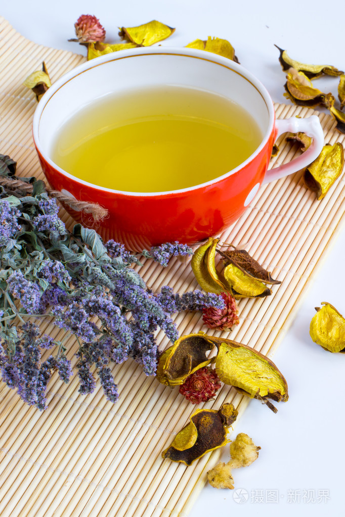 在红杯中的凉茶,干马郁兰中药对竹垫背景