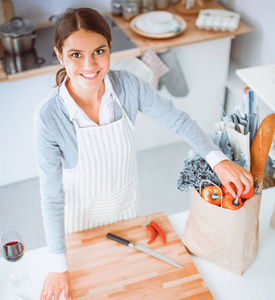 制作健康食品站在厨房里微笑的女人