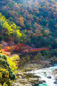 日本 Kyoyo 岚山河上嵯峨风景线或浪漫火车桥上美丽山景的垂直形象