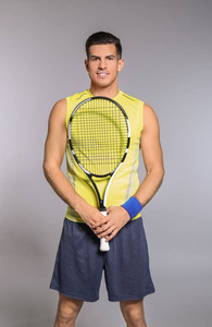 在灰色背景下打网球的英俊男子肖像