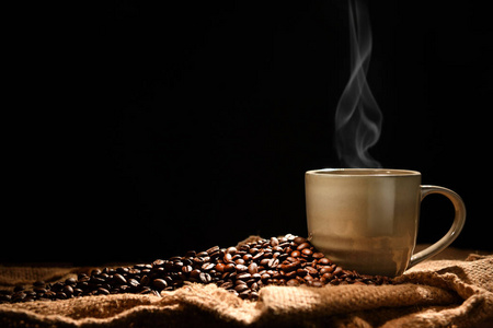 杯咖啡加上黑色背景的烟雾和咖啡豆