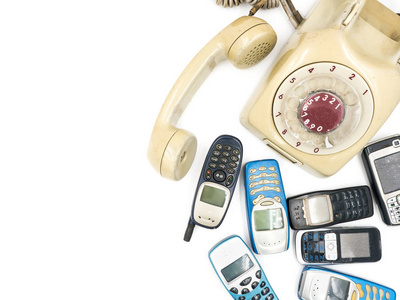 白色背景上的旧电话和移动电话