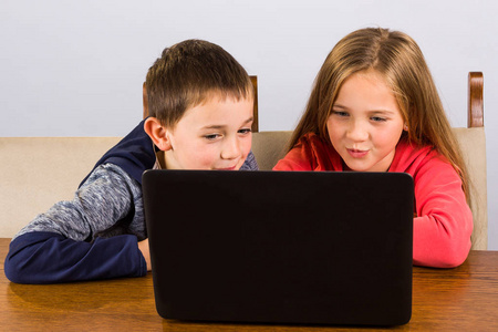 男孩和女孩与便携式计算机