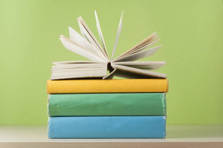 构成与开放书, 精装书在木桌和绿色背景。回到学校。教育背景