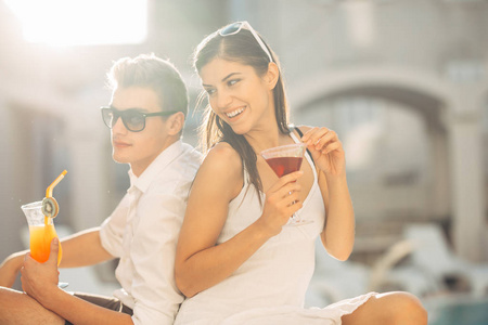 泳池酒吧派对情侣在异国情调的旅游假期享受清爽的饮料和放松的一天.