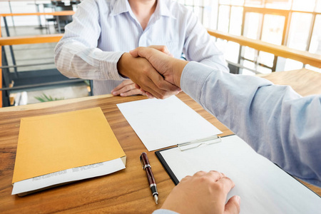 两个信心十足的商业人的办公室 处理 问候 成功的合作伙伴的概念在会议期间握手