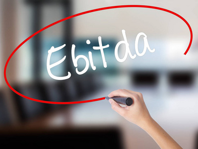 女人的手写作 Ebitda 用记号笔在透明板