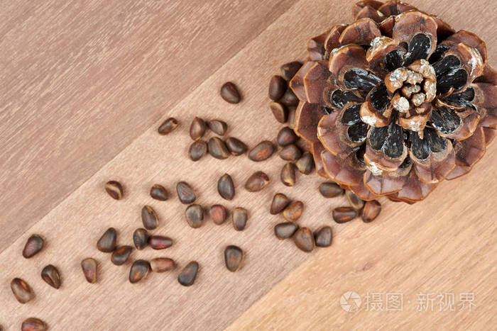 在心木板背景上的松果和松子