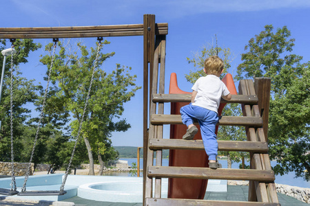 婴儿爬走小男孩爬梯子上幻灯片照片