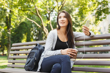 学生坐在公园和使用智能手机