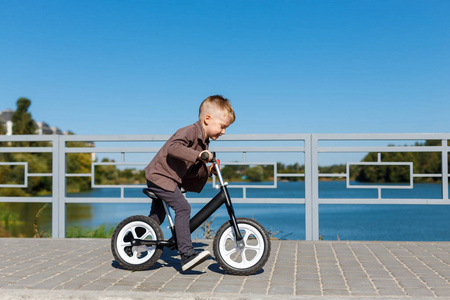 快乐四岁男孩骑自行车没有踏板上的 ba