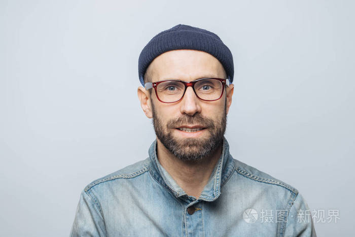 英俊时尚男性记者的肖像戴眼镜 时髦的帽子和牛仔夹克 对白色工作室的背景构成 有茬的人有蓝眼睛 外表宜人 照片 正版商用图片0fksln 摄图新视界