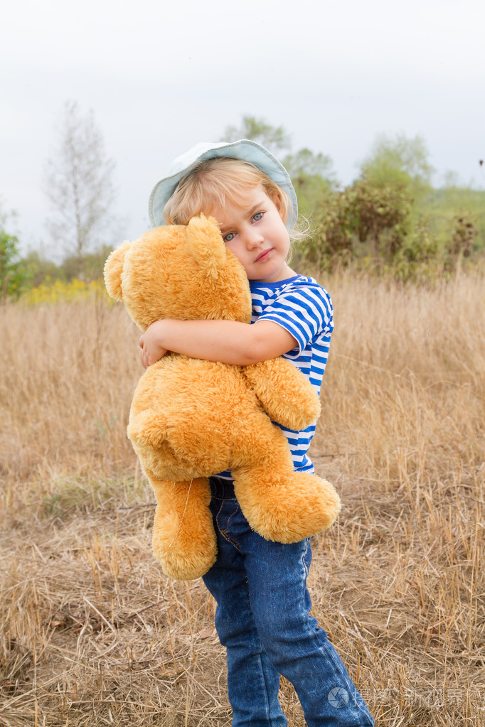 可爱的小女孩抱着很大的熊