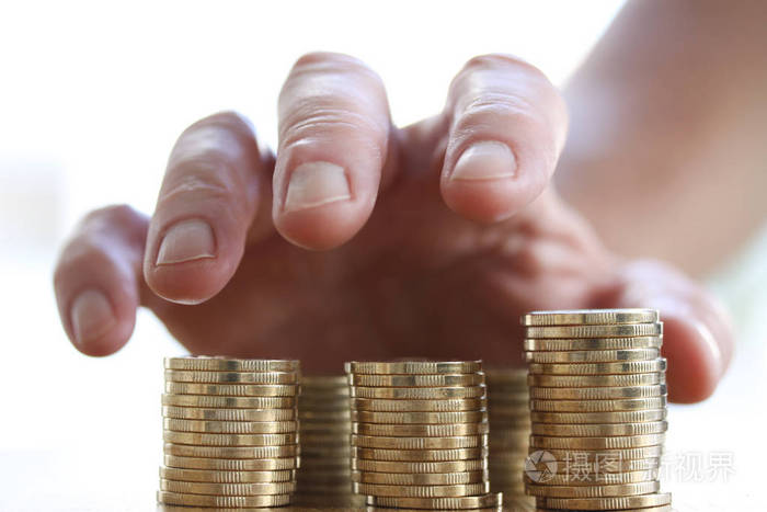 金钱的爱-贪婪的手抓住或伸手去买一堆金币.