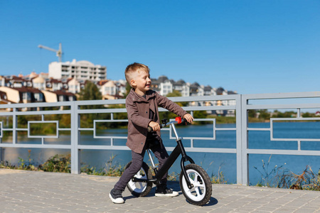 快乐四岁男孩骑自行车没有踏板上的 ba