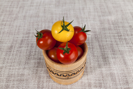 新鲜的红色和黄色樱桃西红柿在一个木制的乡村风格的罐子