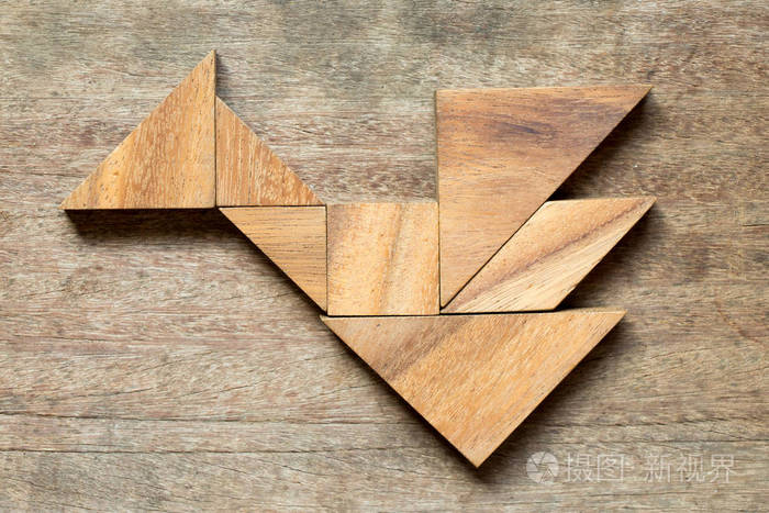 七巧板在木质背景下的鸟或龙形拼图