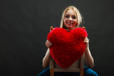 女人抱着心脏形的枕头爱标志
