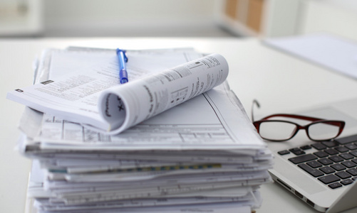 堆栈的文件夹在白色背景上桌上的笔记本电脑照片