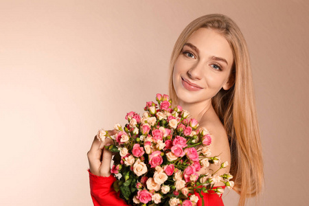 美丽的年轻女子与玫瑰花束在颜色背景