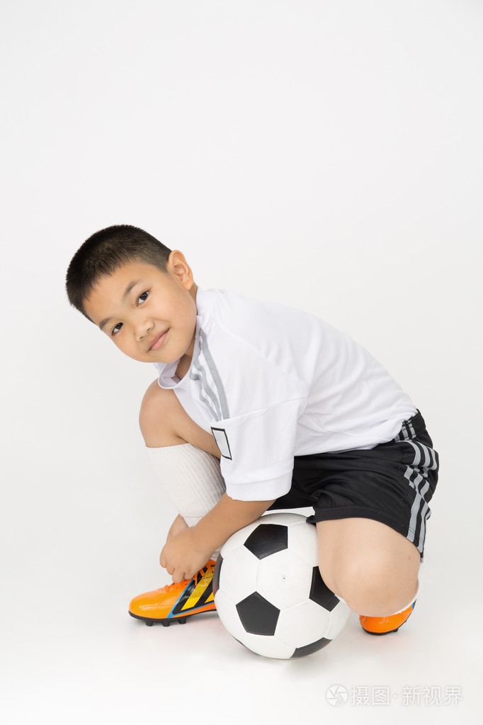 小亚洲男孩可卡犬球的运动制服的肖像