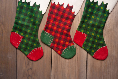 袜子装饰用的壁炉上挂着的三个圣诞袜挂礼物的圣诞袜圣诞袜和花环挂在