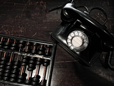 古董拨号电话和算盘在木桌上