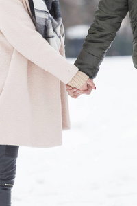 情侣牵手走在雪地上在滑雪场上情侣情侣散步在冬天雪微笑的年轻夫妇在