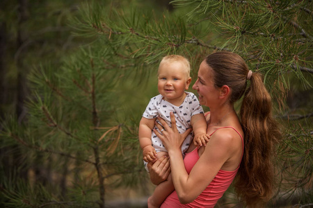 一个女人与她的儿子在绿色松林的肖像