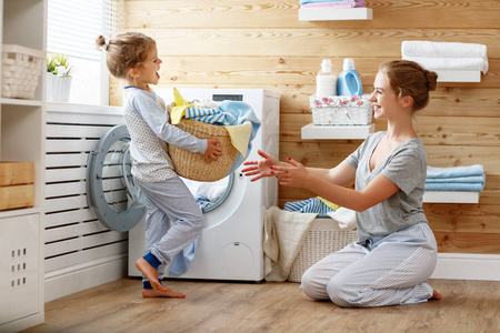 快乐家庭母亲的家庭主妇和孩子在洗衣店与塑封照片