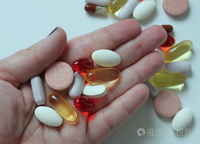 妇女手里的各种药丸和药品