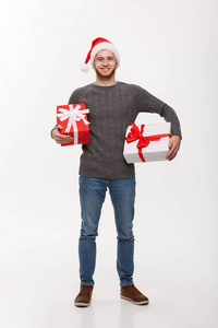 圣诞理念带着胡子的快乐年轻人带着许多在白色背景上被隔绝的礼物。