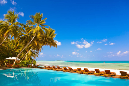 躺椅和马尔代夫海滩上的游泳池