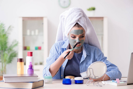 在家用刷子涂抹粘土面具的妇女