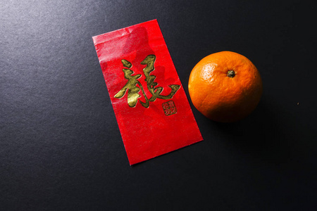 中国农历新年的节日装饰品 红包和柑橘，金色的中文信意味着运气
