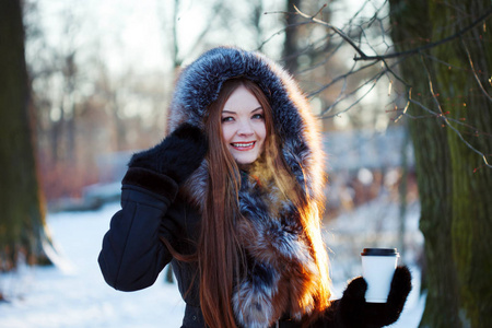 年轻和有魅力的女人上走着，冬天，温暖的外套罩，咖啡去
