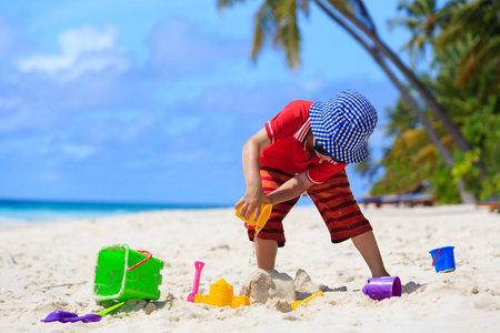 在沙滩上玩沙子的小男孩